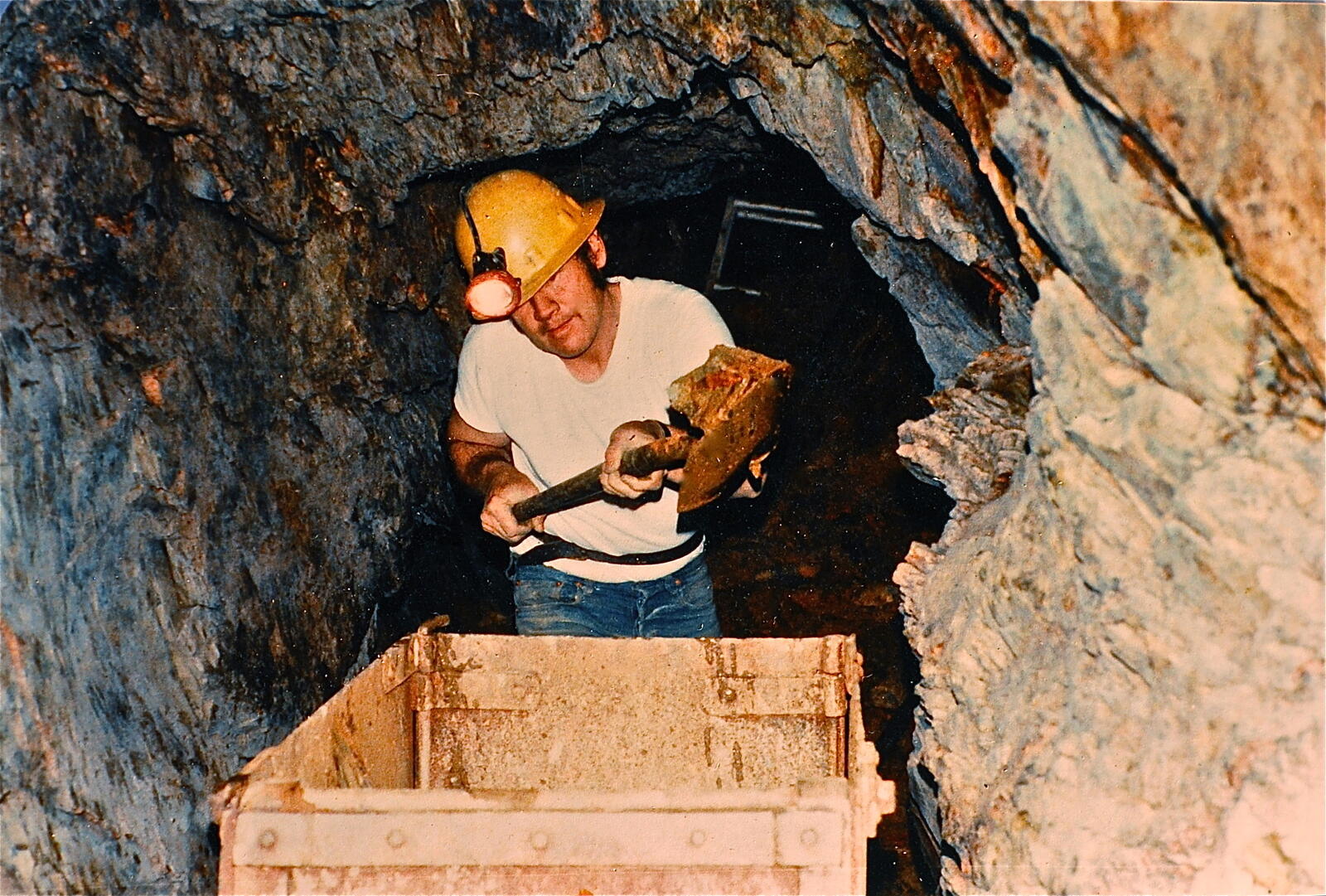 Gary, Don's father, in the workings of the Red Wing in the 1980s, hard hat with headlamp burning, shoveling ore into the iron ore cart.