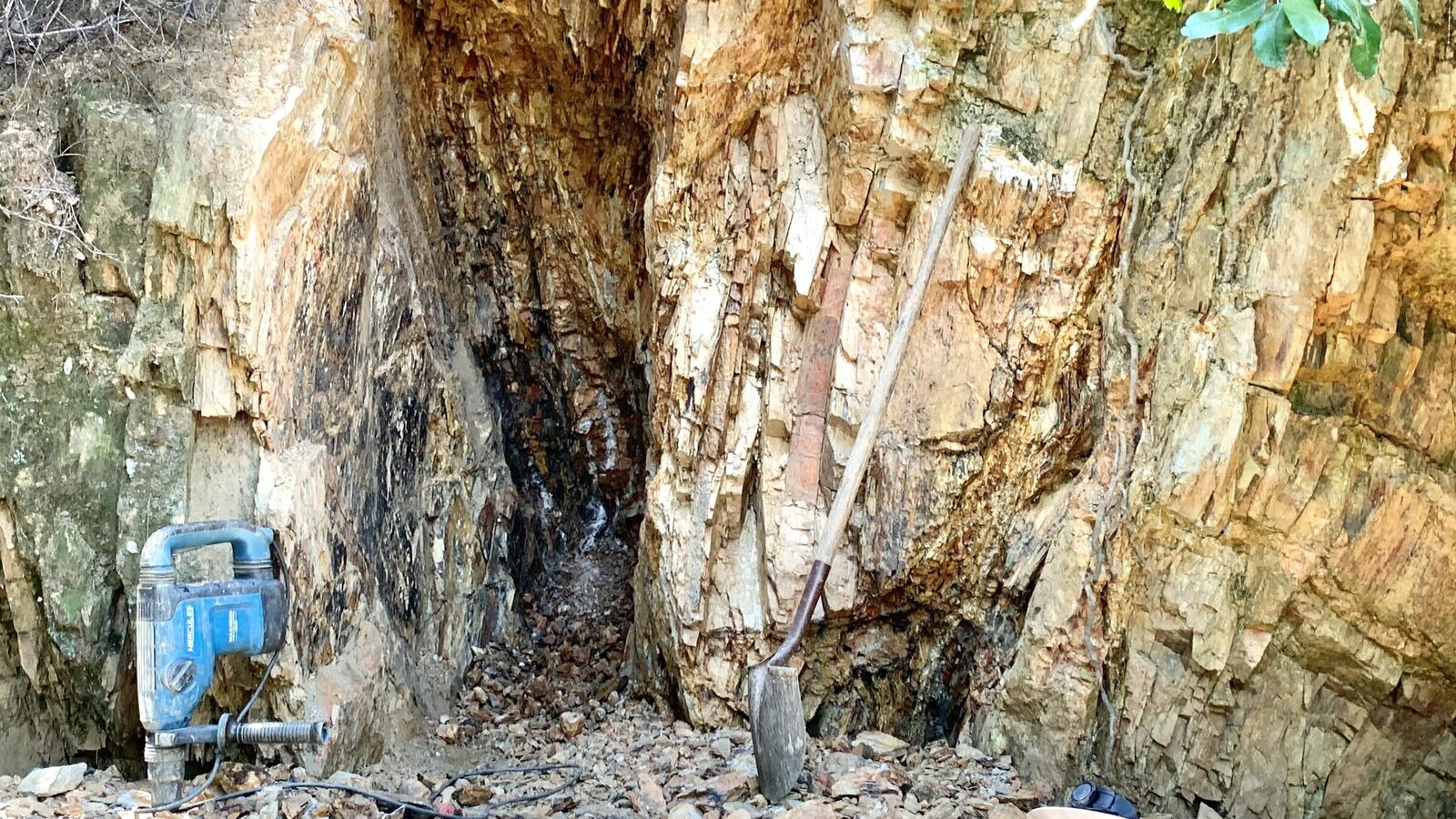 A surface vein outcrop at the Red Wing with a rotor hammer and a shovel leaned against it.