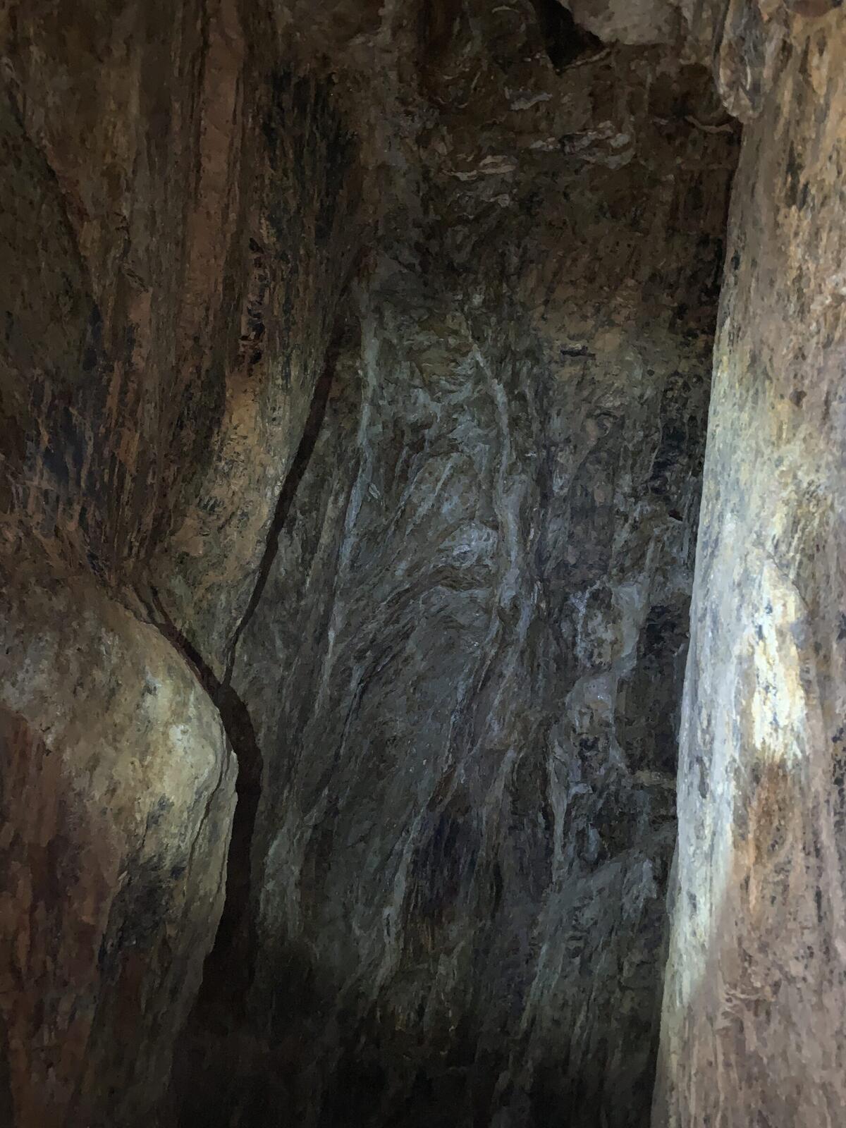 A quartz vein cutting across the dark slate back of a drift inside the Red Wing workings.